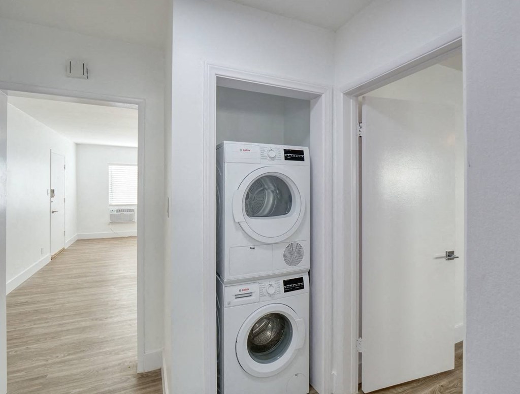 a white laundry room with a washing machine and a dryer