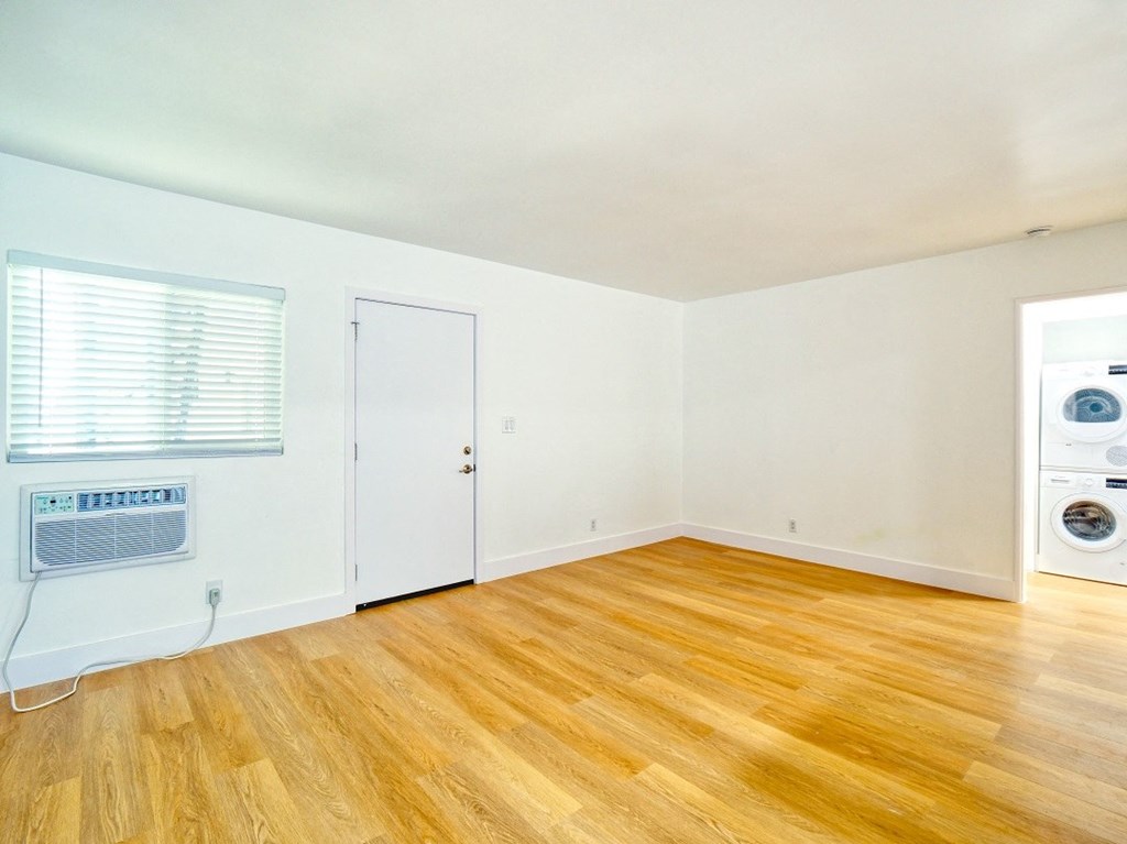 an empty room with white walls and a washer and dryer in it