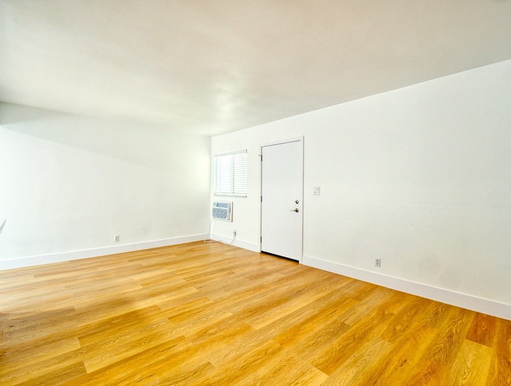 a living room with a wood floor and white walls