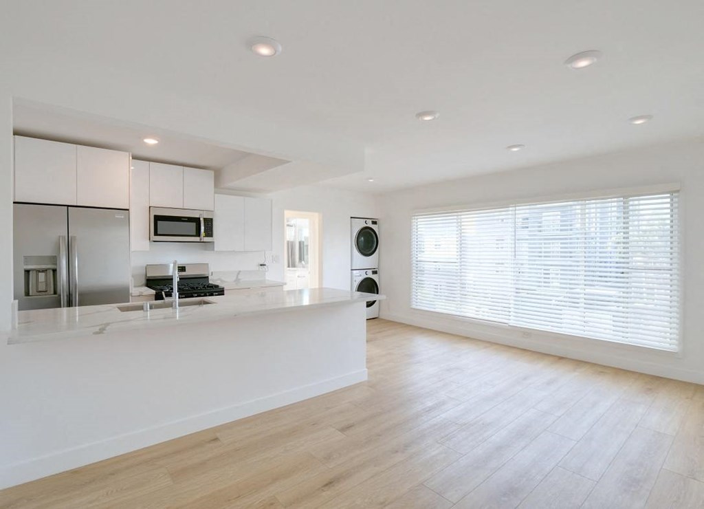an open kitchen and living room with a large window