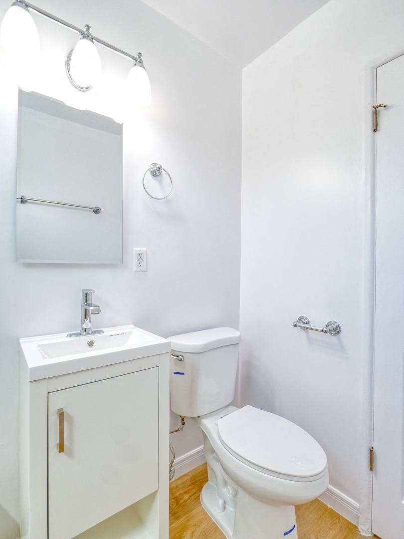 a bathroom with a toilet sink and a mirror