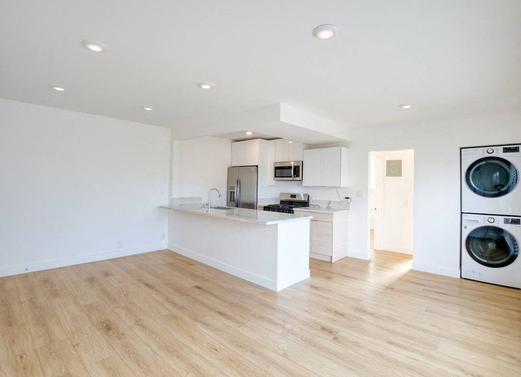 an empty kitchen and laundry room with a washer and dryer
