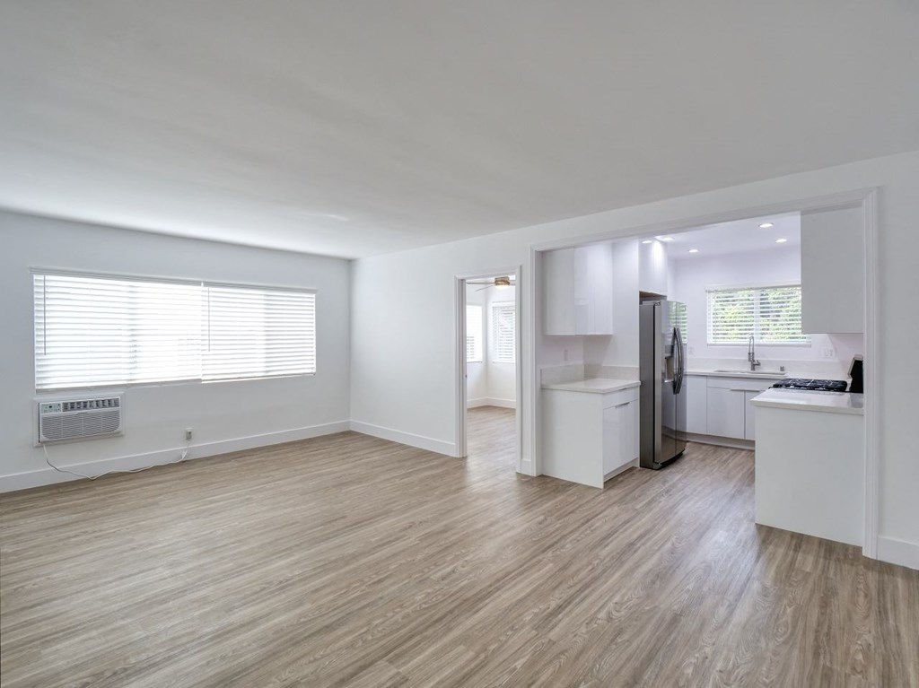 the living room and kitchen of an empty apartment