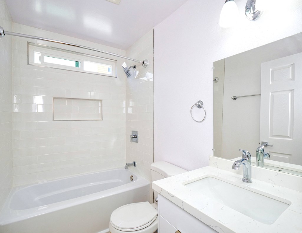 a white bathroom with a tub sink and toilet