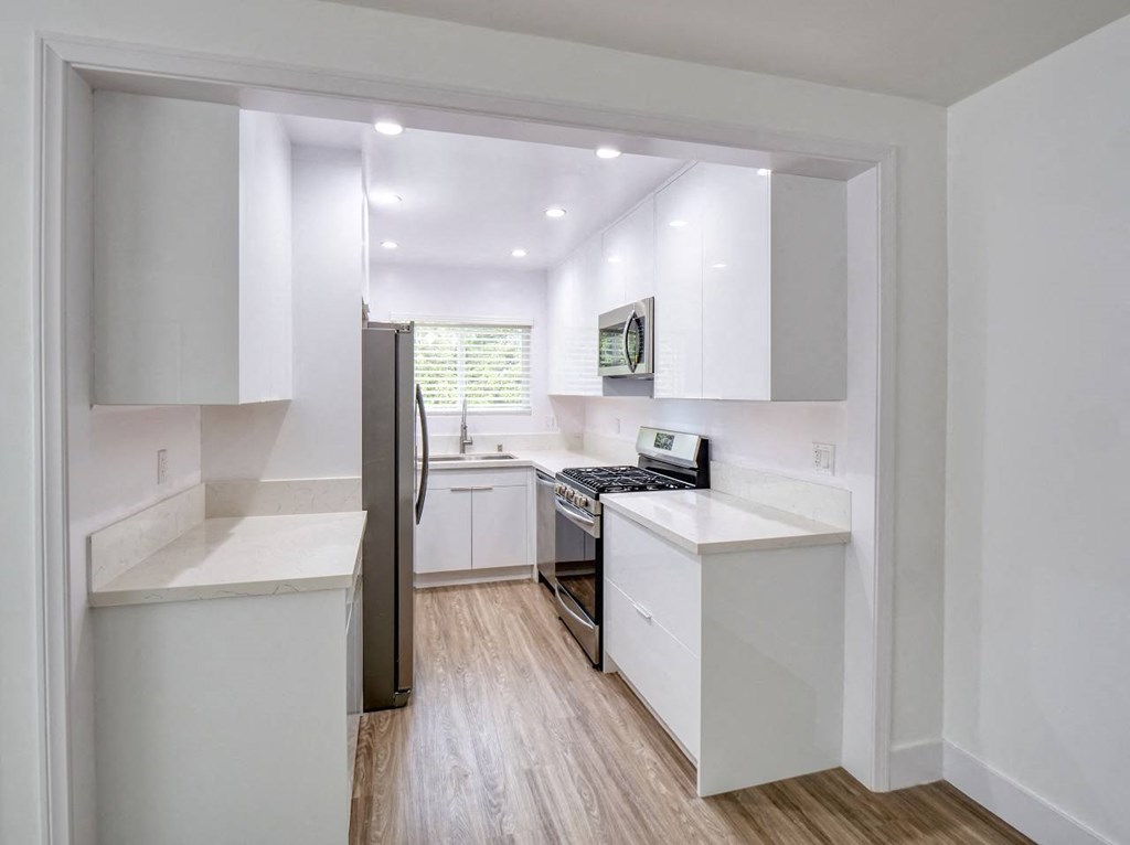 a kitchen with white cabinets and a stainless steel refrigerator