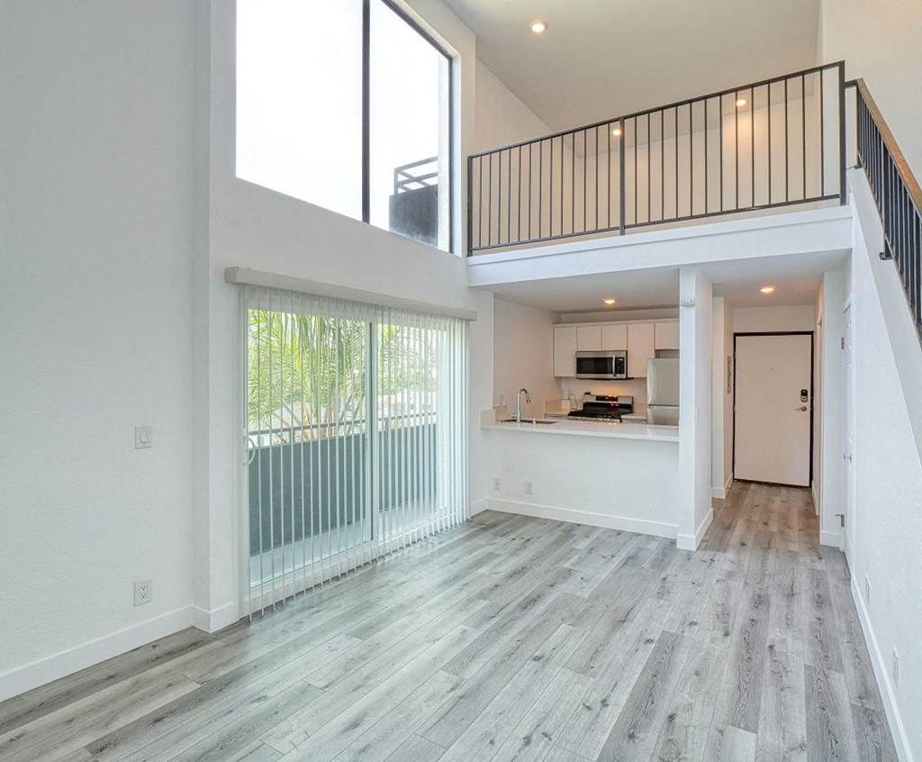 an open living room with sliding glass doors to a kitchen