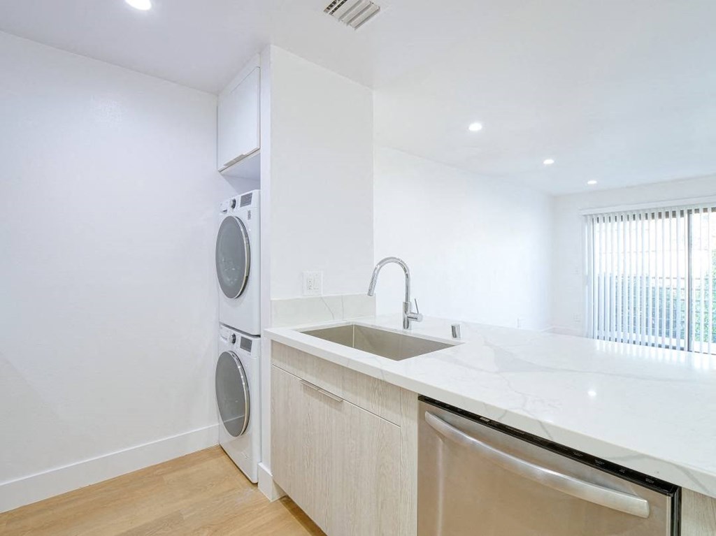 a white kitchen with a washing machine and a sink