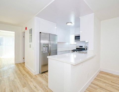 a kitchen with white cabinets and a stainless steel refrigerator