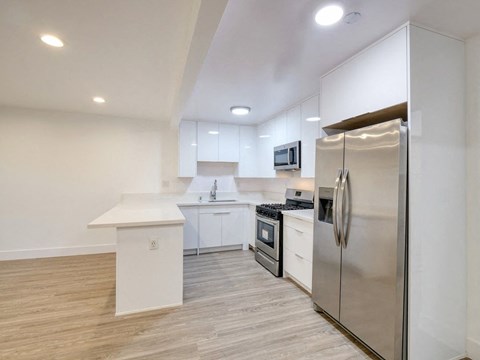 a kitchen with stainless steel appliances and white cabinets