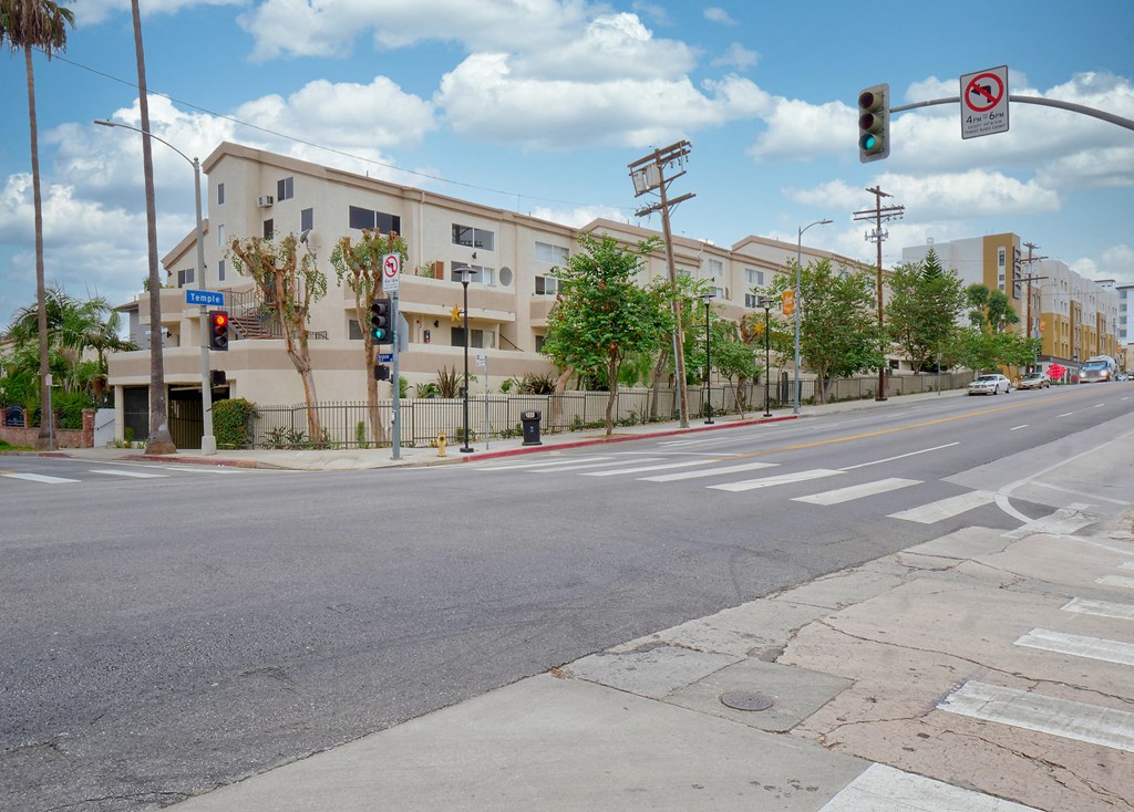 an apartment building on a street corner with a traffic light