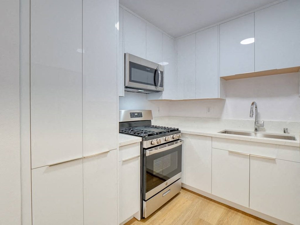 a white kitchen with a stove and a microwave