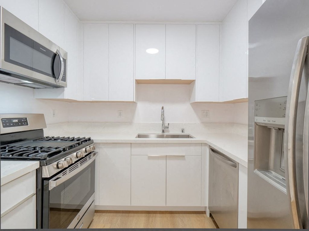 a kitchen with white cabinets and stainless steel appliances