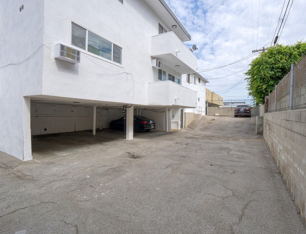 the side of a white building with a parking garage
