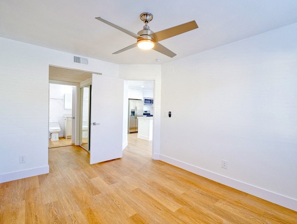 a living room with wood floors and a ceiling fan