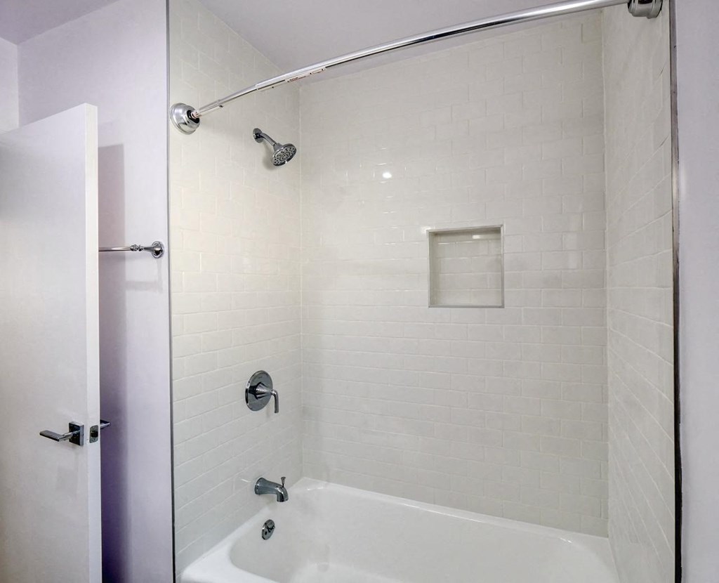 a white bathroom with a shower and a sink