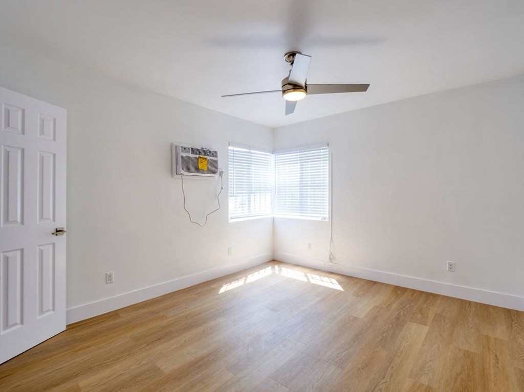 an empty room with a ceiling fan and a window