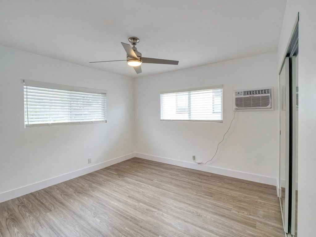 an empty room with a ceiling fan and a window