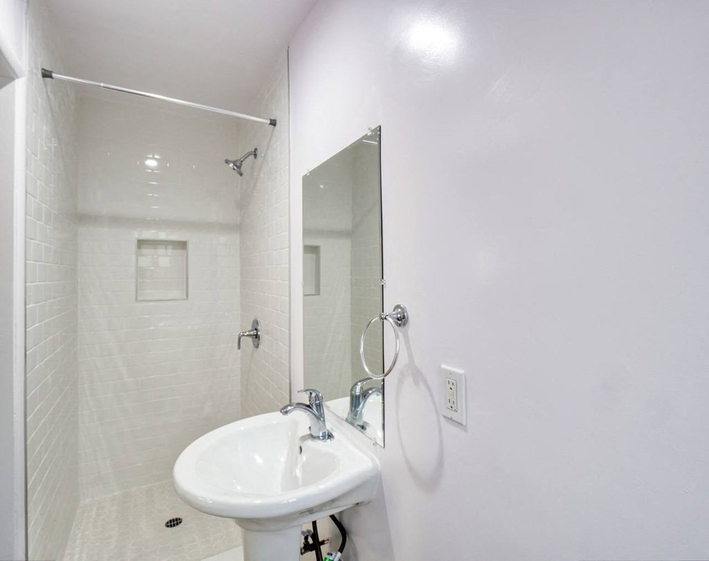 a white bathroom with a sink and a mirror