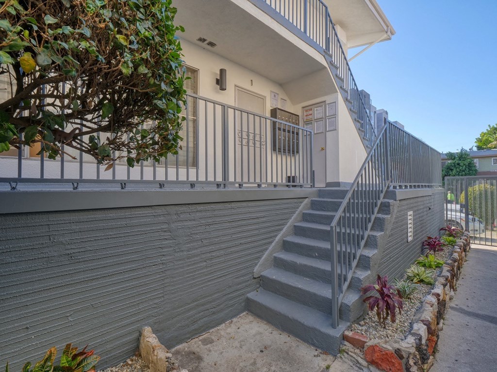 a house with stairs and a fence and a balcony