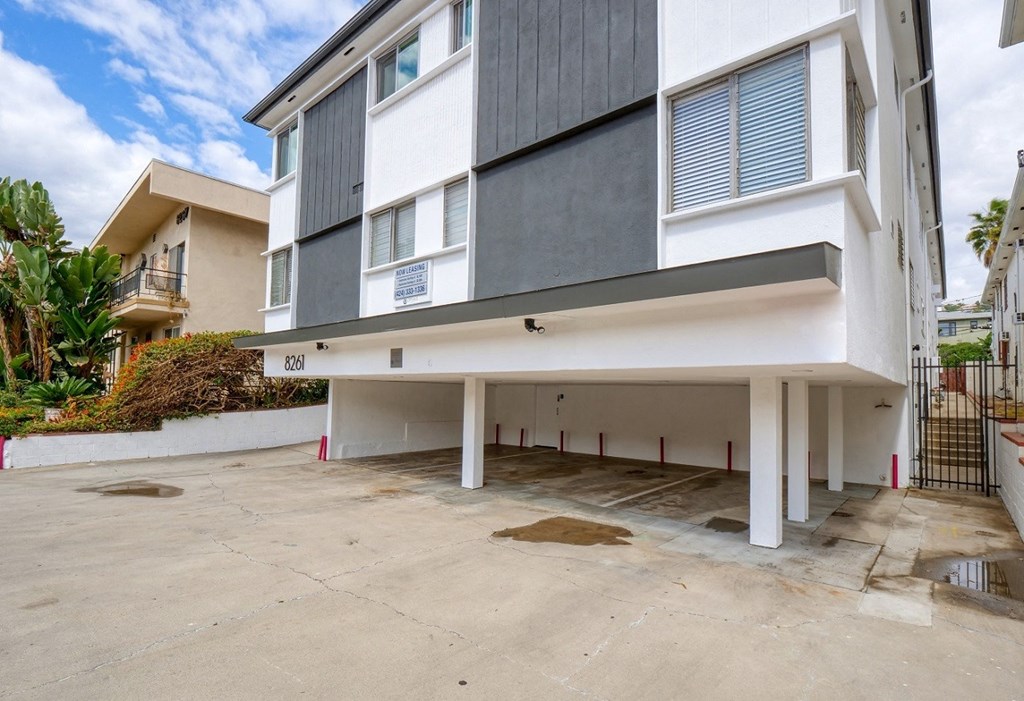 an empty parking lot in front of an apartment building