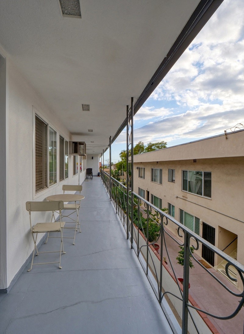 the view from the balcony of a apartment building with tables and chairs