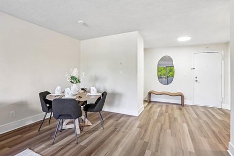 A dining room with a table set for four.