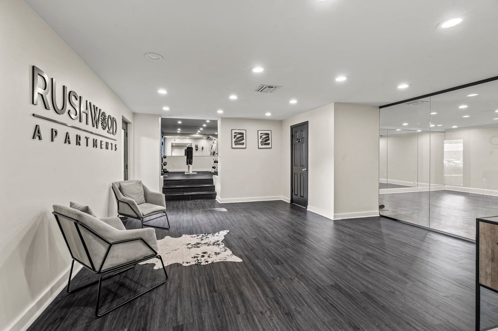 a waiting room with two chairs and a rug in front of a patient entrance