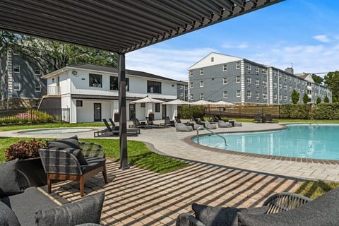 a pool with lounge chairs and umbrellas at the enclave at woodbridge apartments in sugar  at Chestnut Hill Village, Philadelphia, Pennsylvania