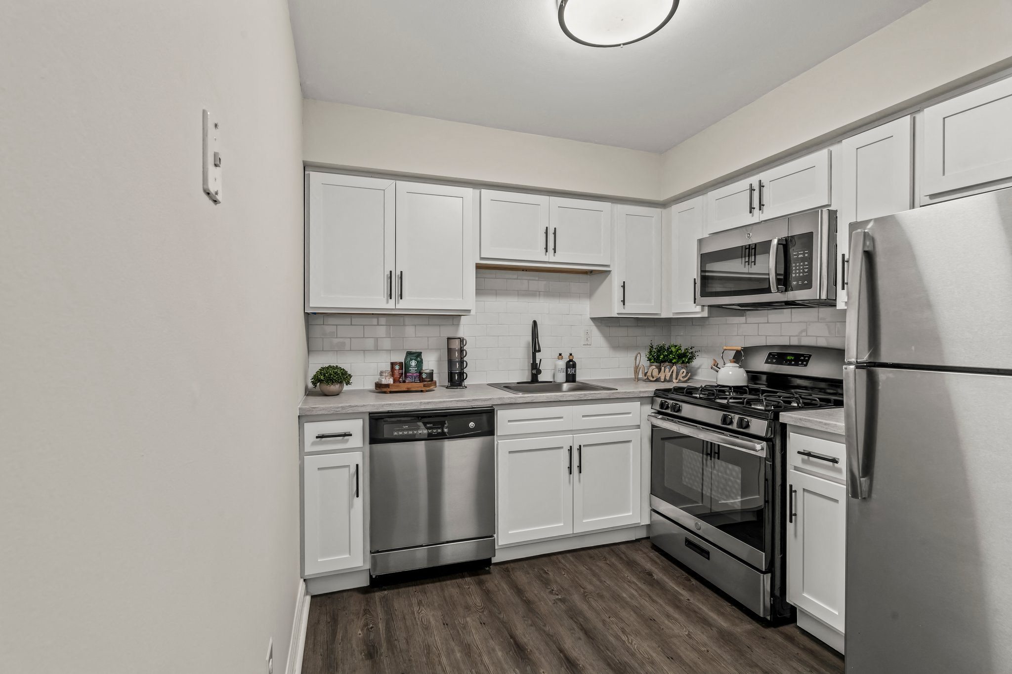 an empty kitchen with stainless steel appliances and white cabinets at Rushwood Apartments, Philadelphia, Pennsylvania