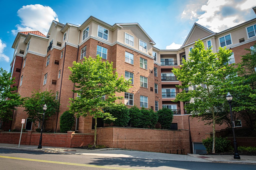 a red brick apartment building with trees in front of it at Park Square Apartments, New Jersey, 07065