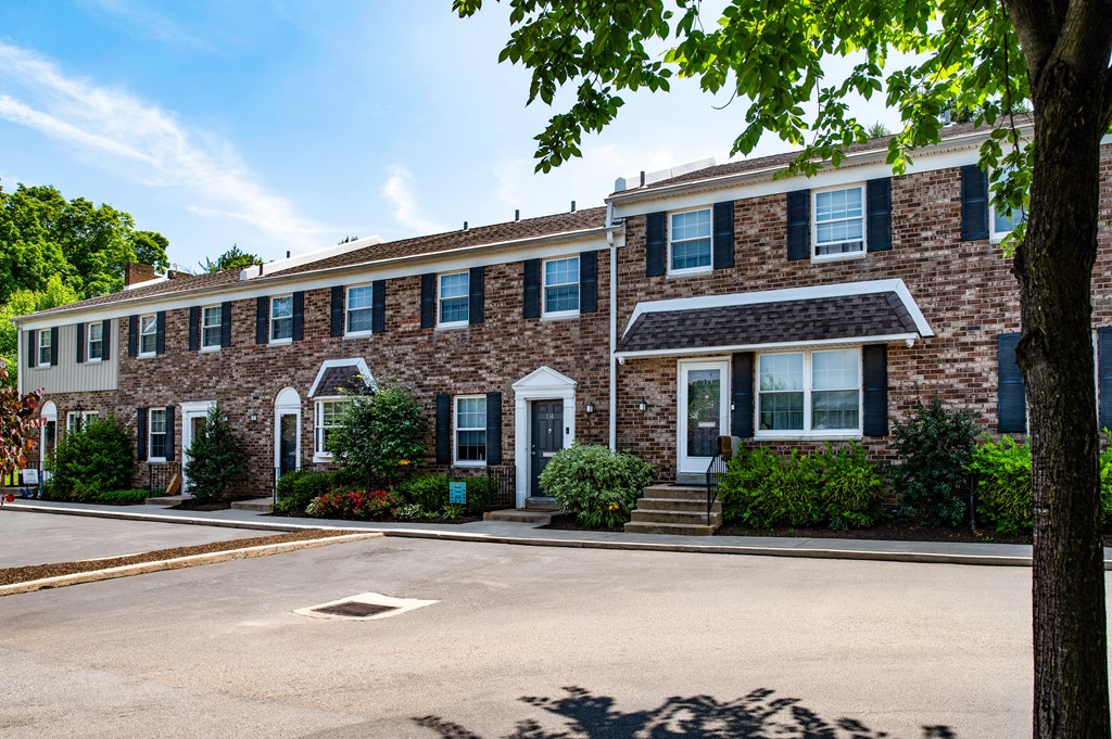 A row of houses with green bushes in front.