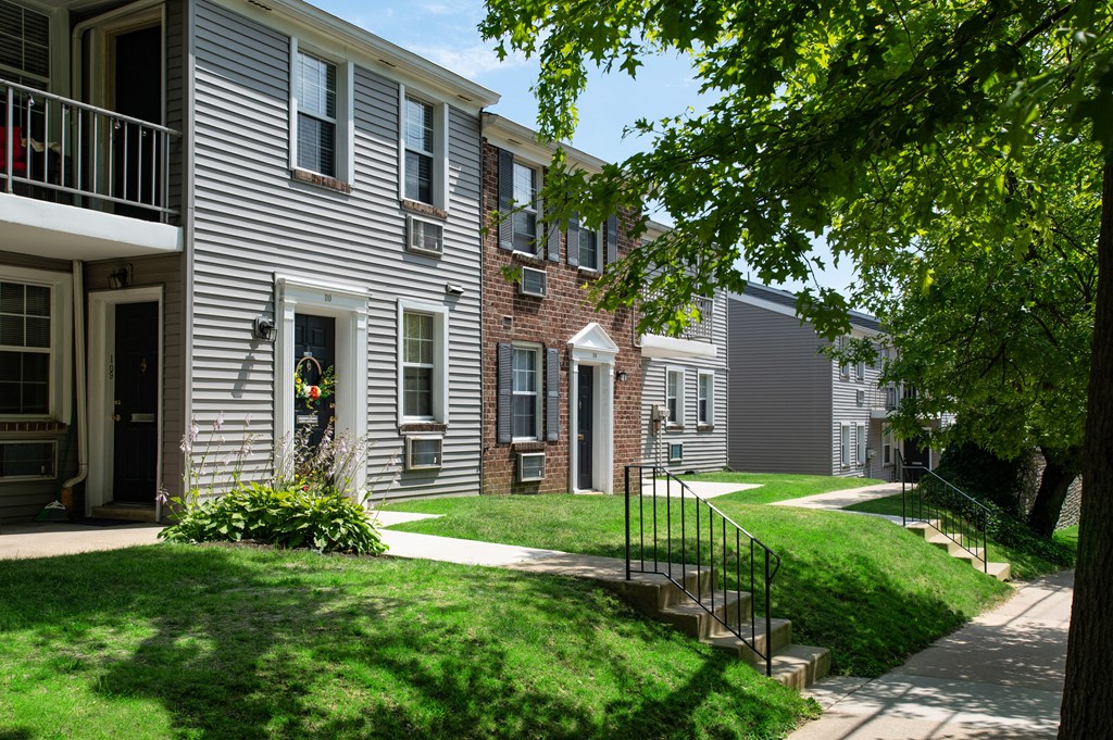 A row of houses with green lawns in front.