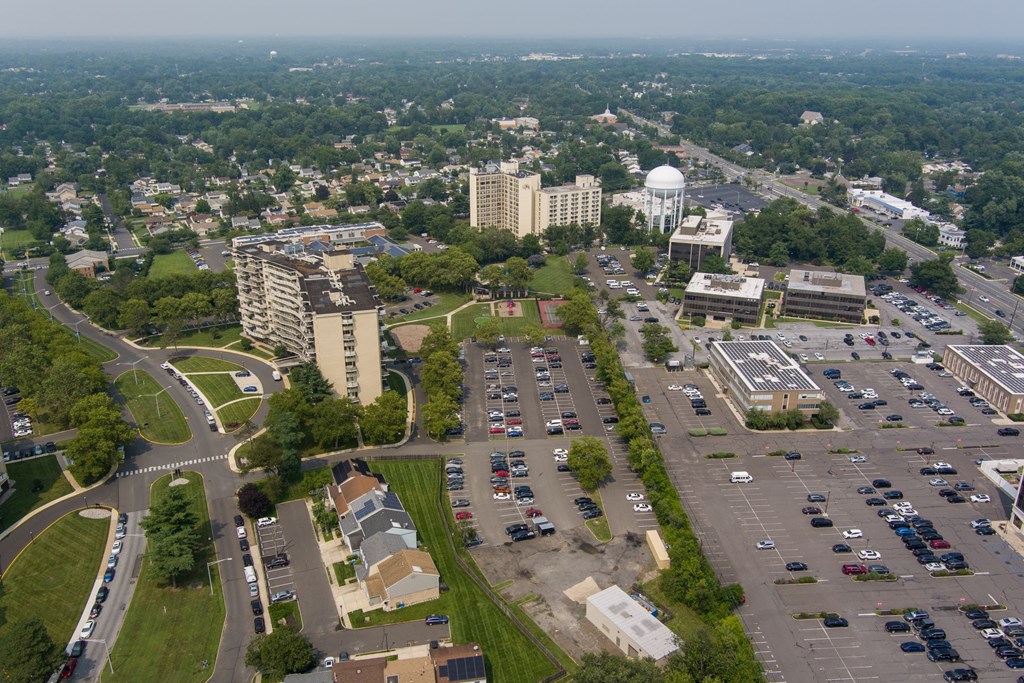 A parking lot is in the foreground of a city scene.