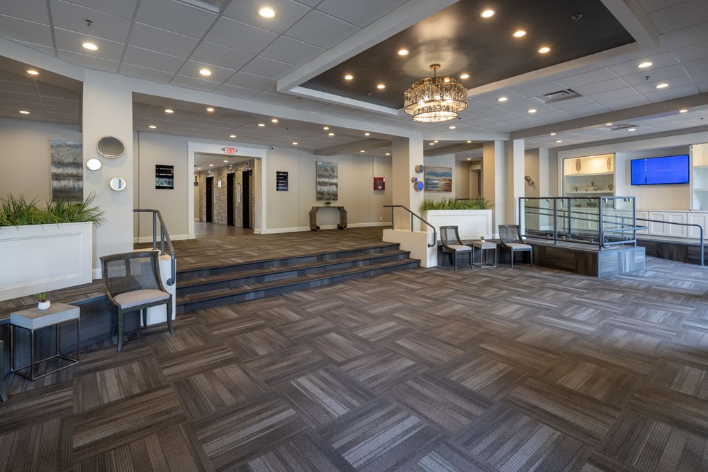 A large room with a wooden floor and a chandelier hanging from the ceiling.