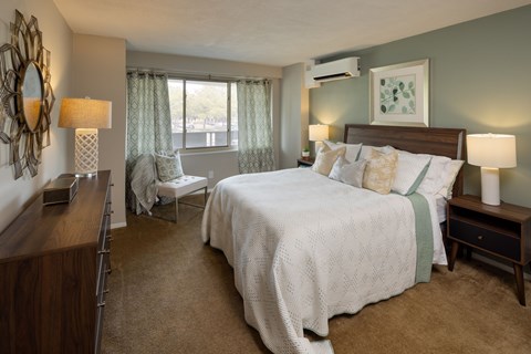 A bedroom with a large bed and a mirror on the wall.