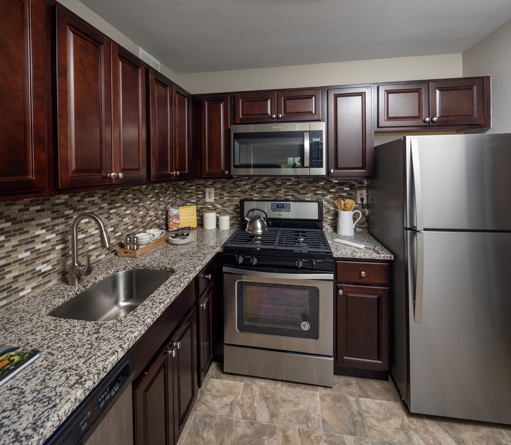 A kitchen with brown cabinets and stainless steel appliances.