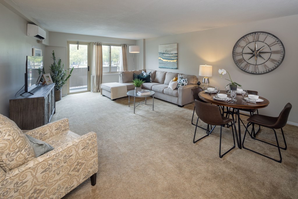 A living room with a couch, chairs, and a dining table.