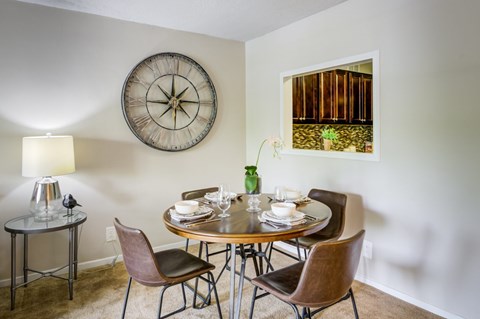 A dining room with a round table and chairs.