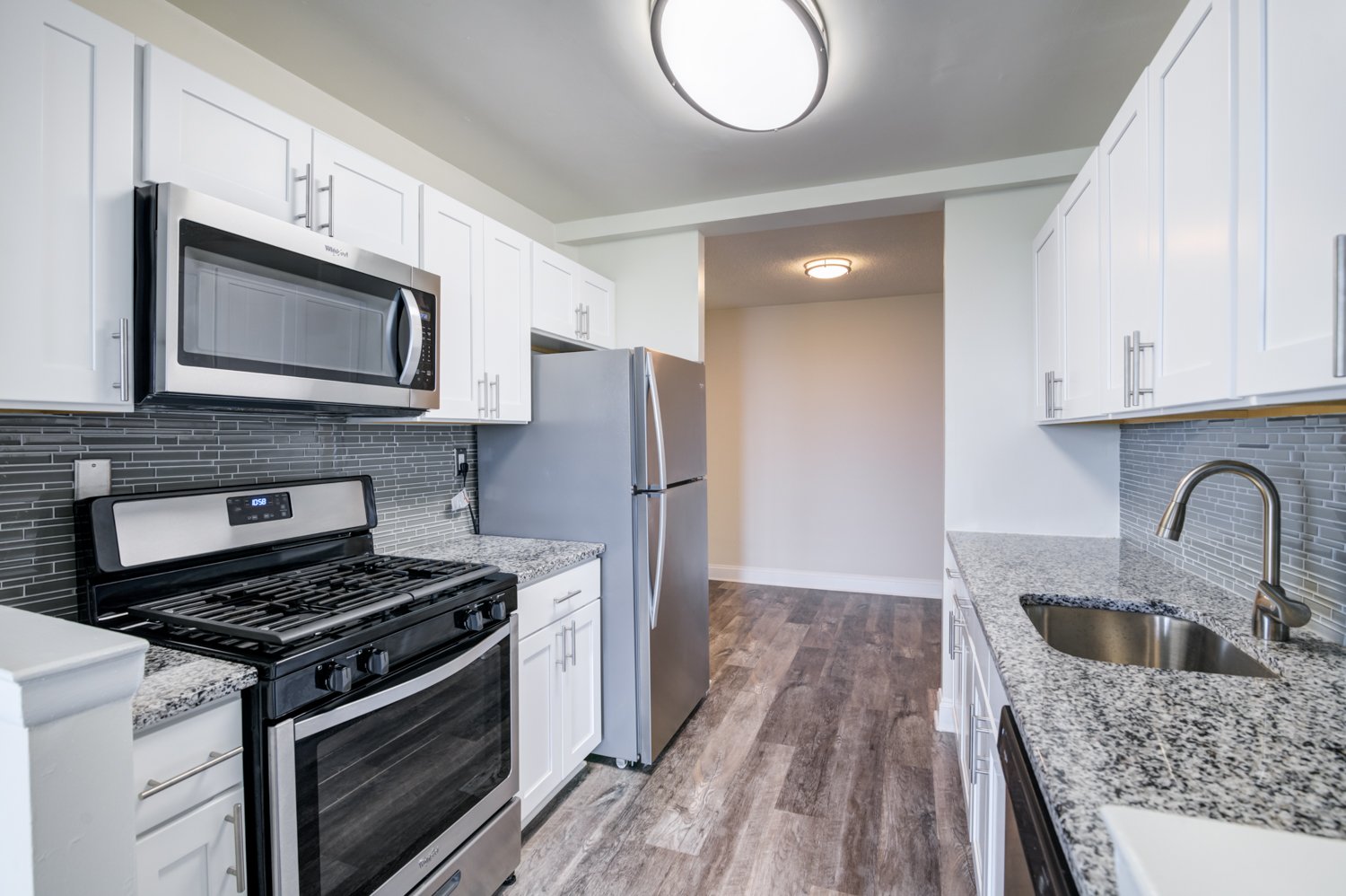 A kitchen with a black stove top oven and a black microwave above it.