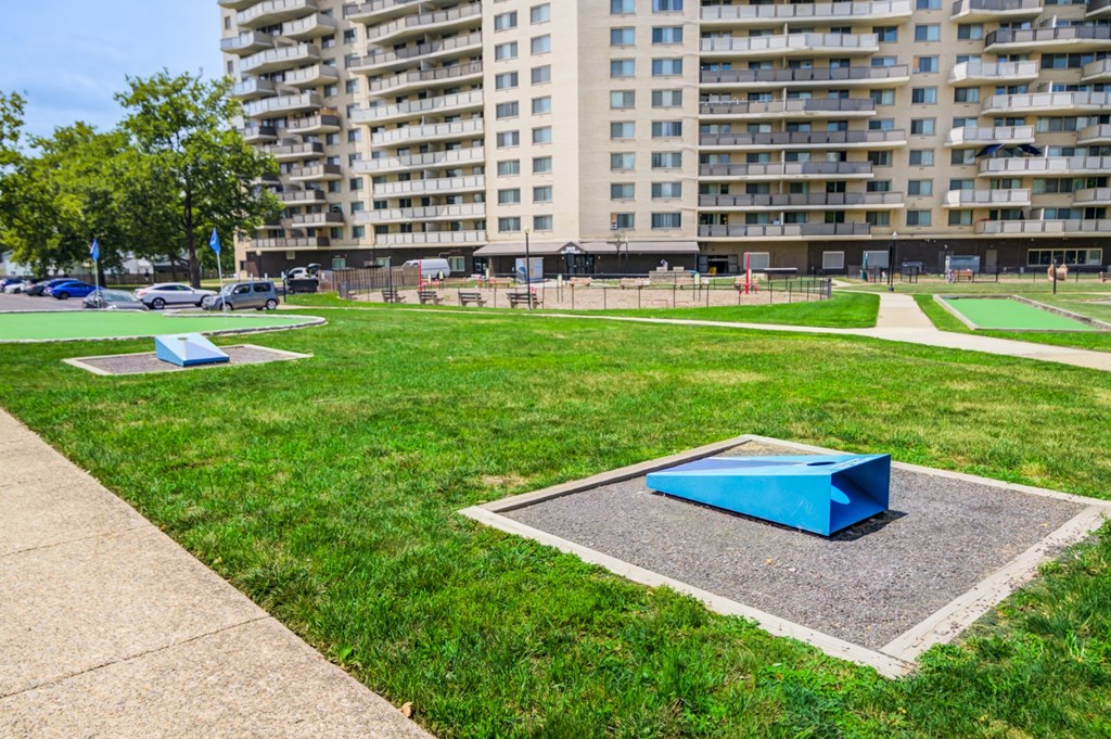 A park with a blue object in the middle of a concrete square.