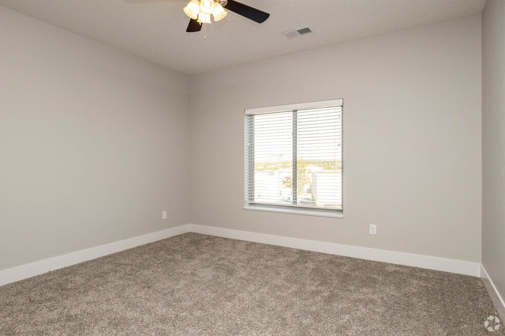an empty room with a window and a ceiling fan