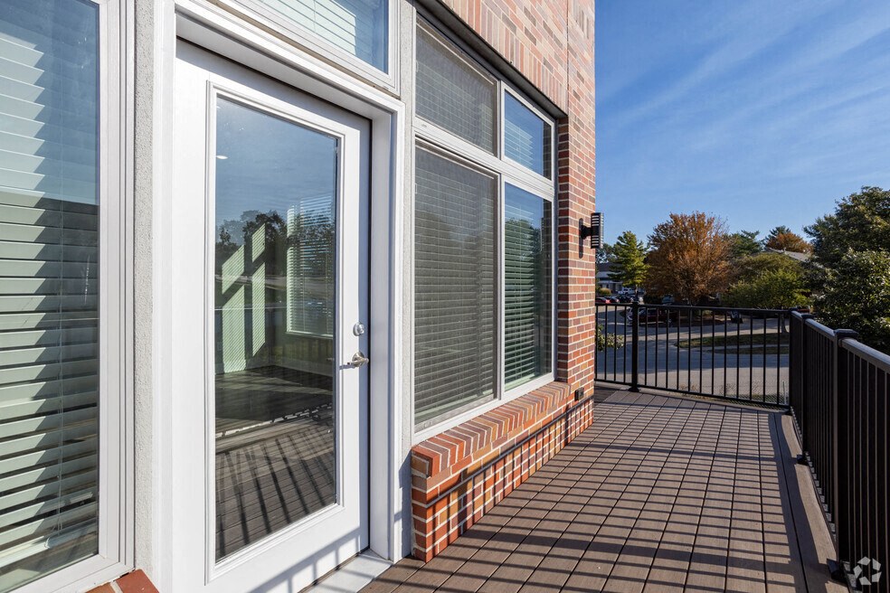 the balcony of a home with windows and a door