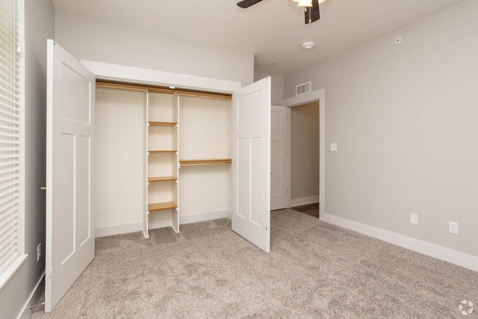 an empty bedroom with a closet and shelves