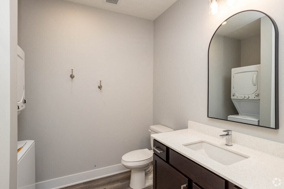 a bathroom with a mirror and a sink and a toilet