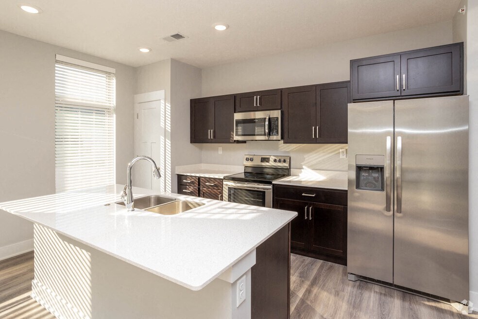 a kitchen with stainless steel appliances and a white counter top