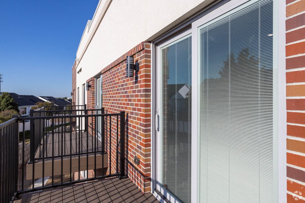 the view of the balcony of a house with a door and a balcony railing
