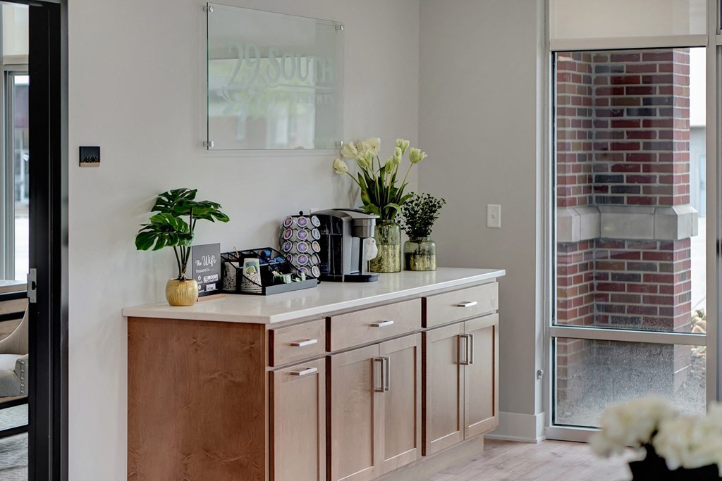 a kitchen with wooden cabinets and a counter with vases and flowers