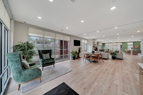 an open living room and dining area with a large window and a table and chairs