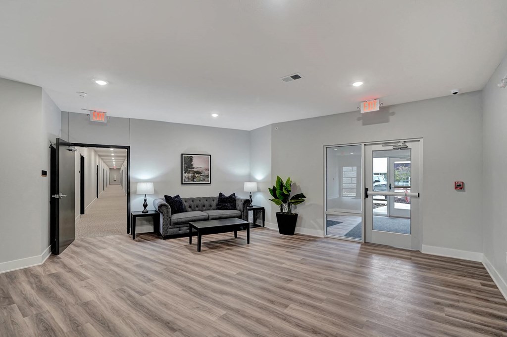 a living room with a couch and a table in front of a door
