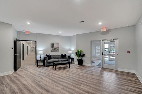 a living room with a couch and a table in front of a door